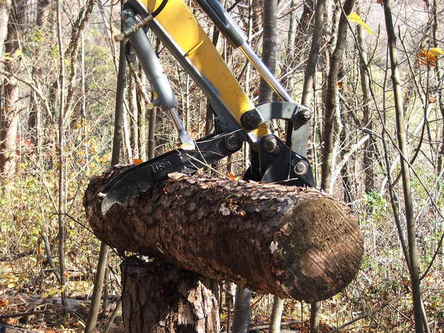 Ht830 mini excavator thumb picking up a log