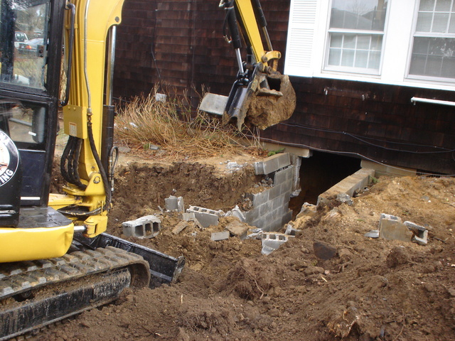 An HT830 mini hydraulic thumb clears out a foundation