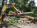 HT830 mini hydraulic thumb, installed on a CAT excavator, picking up two logs.
