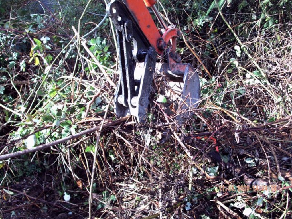 MT618 mini excavator thumb installed on KUBOTA KH-41 clearing out brush