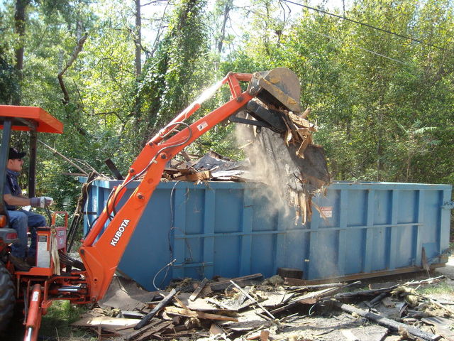 KUBOTA L35 tractor backhoe cleaning debris with a thumb from USA Attachments