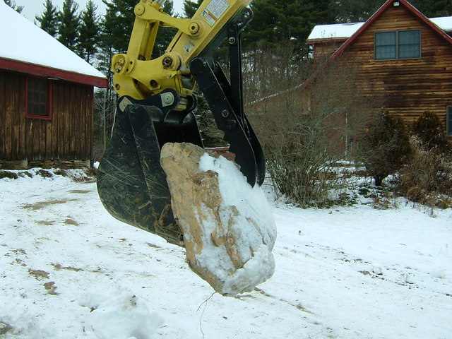 8"x30" mini excavator thumb lifts a large stone