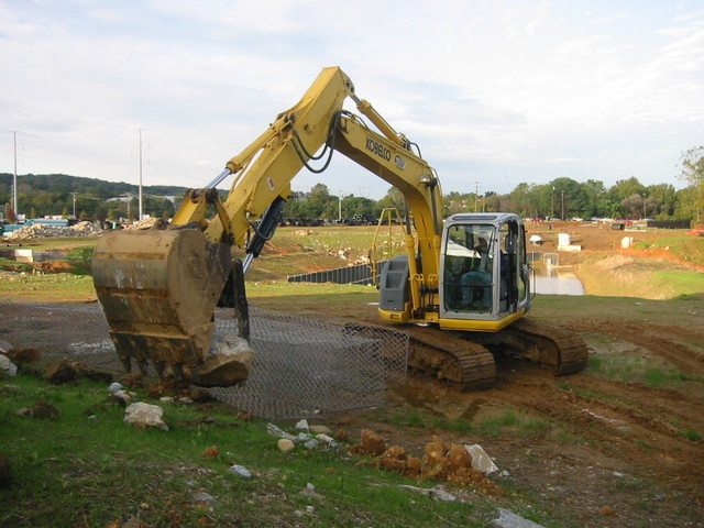 KOBELCO with hydraulic thumb ht1850 picking up a large stone