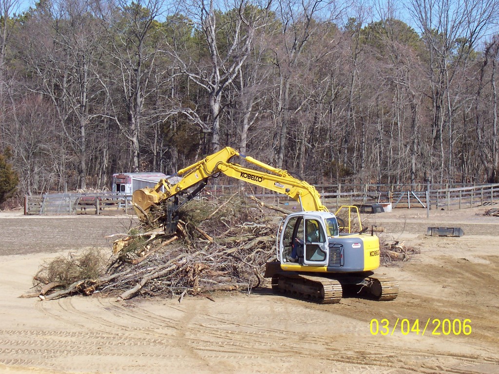 KOBELCO with hydraulic thumb clearing brush