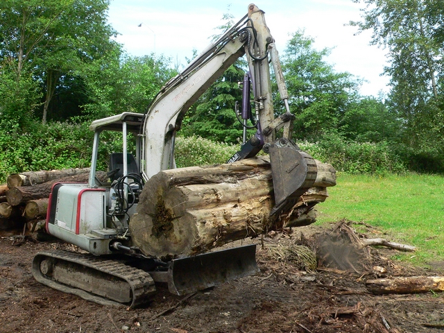 Ht830 hydraulic mini excavator thumb shown lifting a tree log