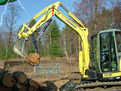 Another view of the YANMAR mini excavator with mini hydraulic thumb picking up a log