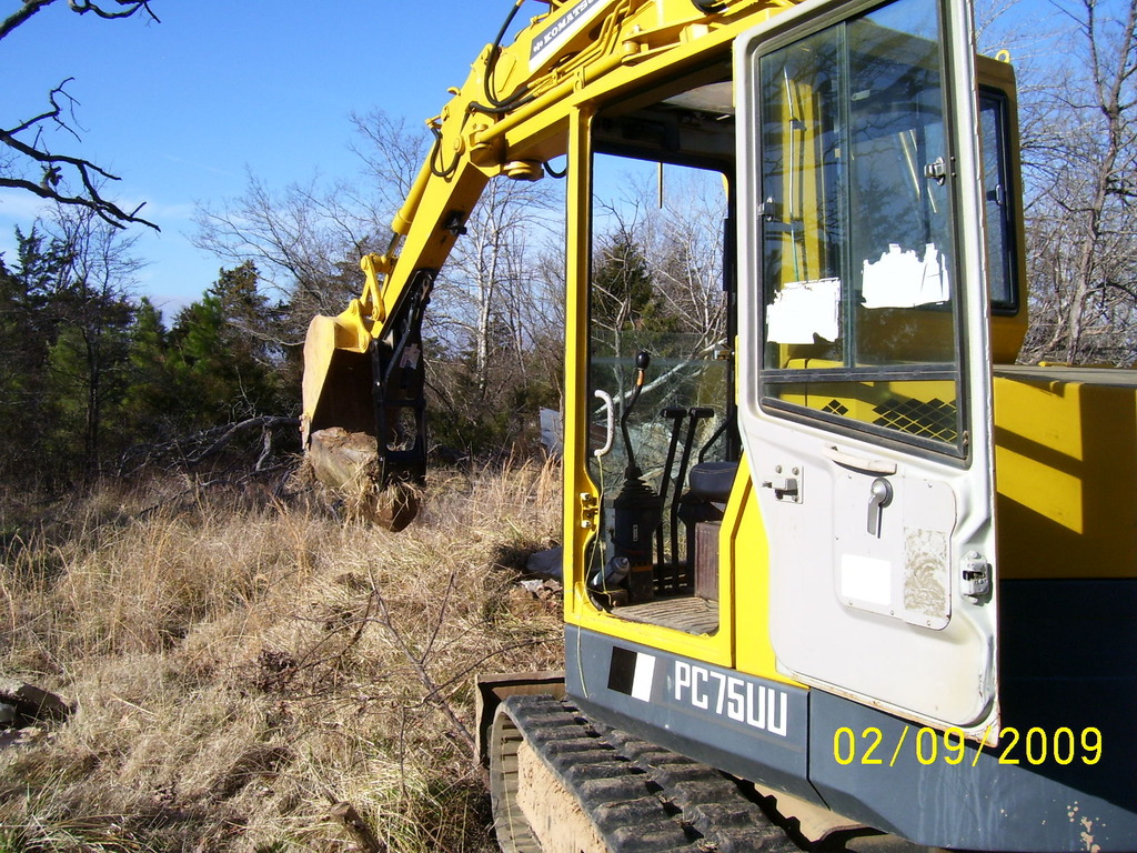 Komatsu PC75UU picking up a large stone with MT140 excavator thumb by USA Attachments