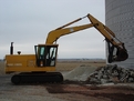 Side profile of an MT2458 thumb working on a Deere excavator