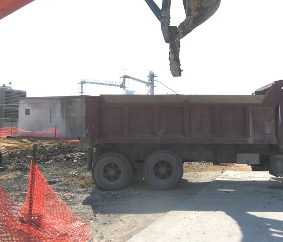 Mt3070 excavator thumb loading material into a dump truck