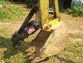 An 6" x 18" mini thumb installed on a Terramite T5C compact loader backhoe.