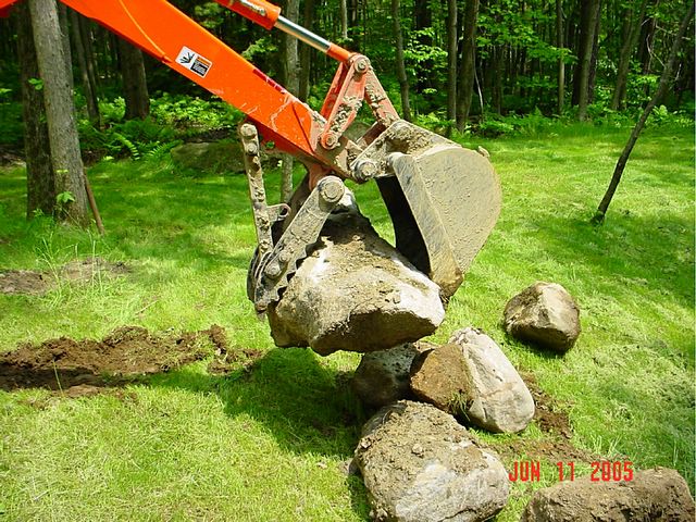 MT824 mini thumb moving stones installed on a KUBOTA L39 mini backhoe.