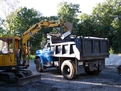 MT824 excavator thumb on DEERE 25 mini excavator loading a dump truck.