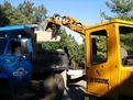 Deere 25 mini excavator loading concrete into a dump truck with 8"x24" mini thumb from USA Attachments
