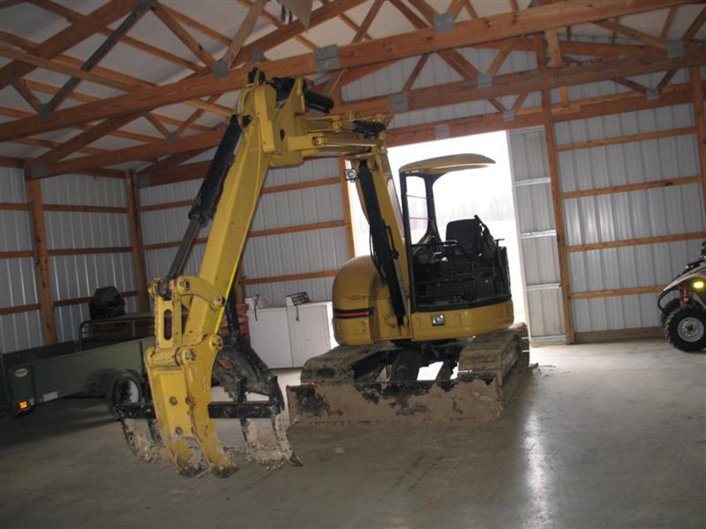 Mt830 mini excavator thumb installed along with a tree stumper and rake from USA Attachments