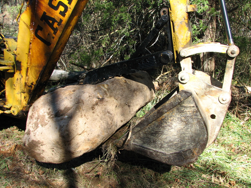 CASE backhoe with MT830 thumb moves stone