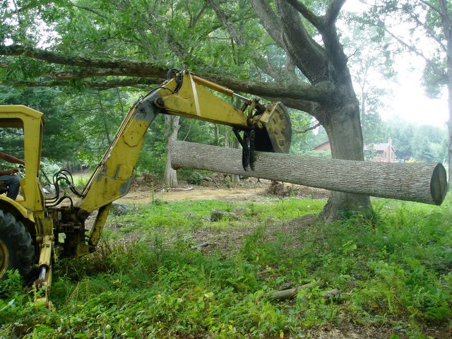 A log is being picked up by this MT830 mini excavator thumb.