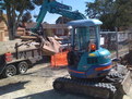 Kubota mini excavator with 8"x30" excavator thumb picks up scrap
